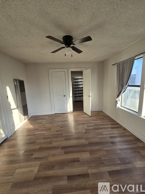 A room with wooden flooring and a ceiling fan.