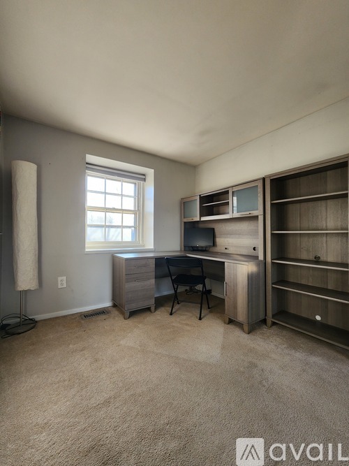 A room with a desk and a chair in it.