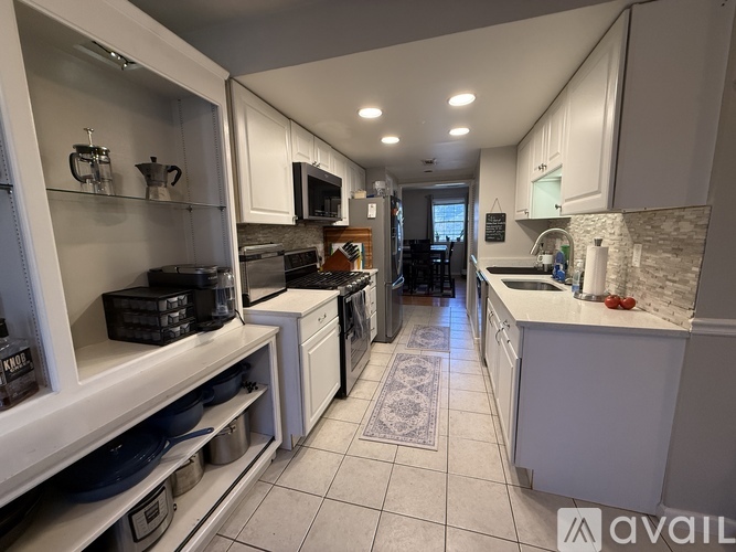 A kitchen with white cabinets and a tile floor.