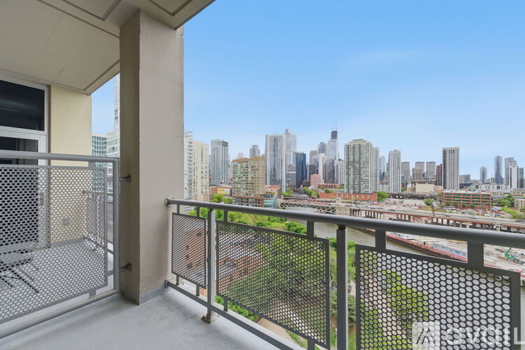 A balcony with a metal railing overlooks a cityscape.
