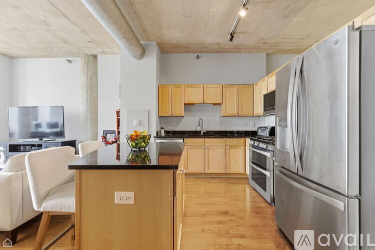 A kitchen with wooden cabinets and a stainless steel refrigerator.