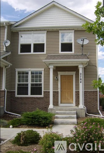 A house with a brown door and a satellite dish on the roof.