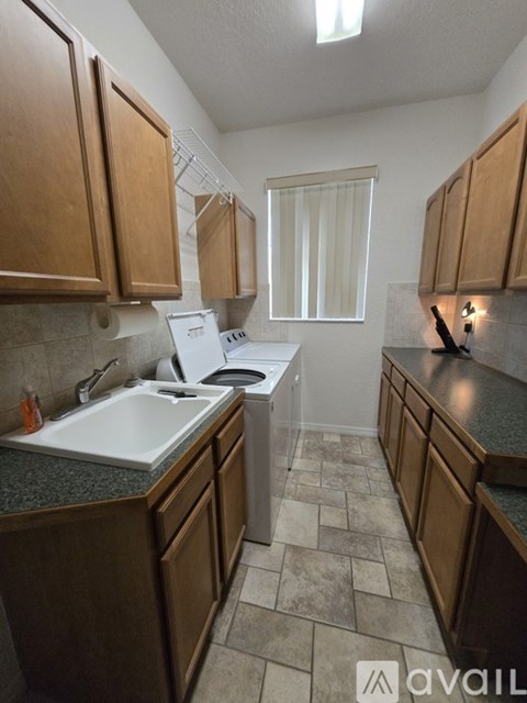 A kitchen with wooden cabinets and a white sink.