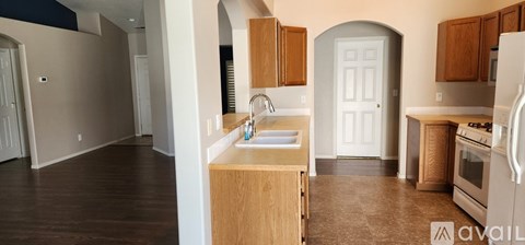A kitchen with a sink, stove, and refrigerator is available for rent.