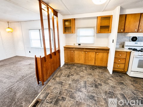 A kitchen with wooden cabinets and a tiled floor.