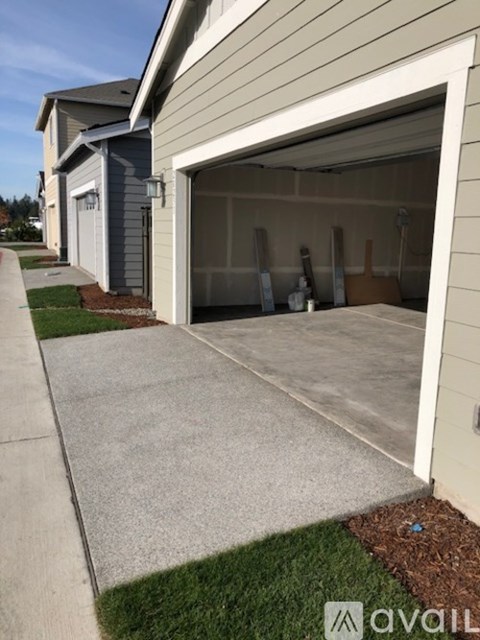 A garage door is open, revealing a clean, empty garage space.