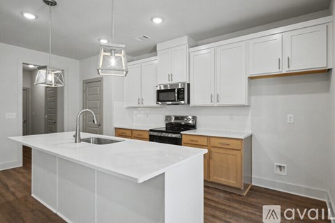 A modern kitchen with white cabinets and a white island.