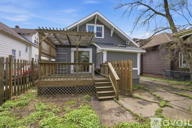 A house with a wooden deck and stairs leading to the entrance.