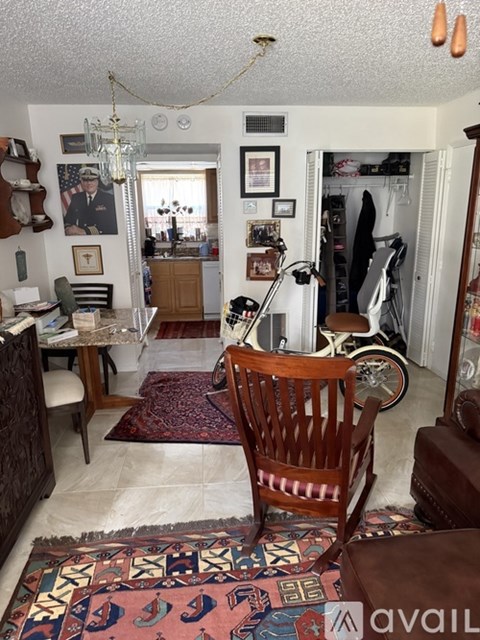 A living room with a rug and a wooden chair.