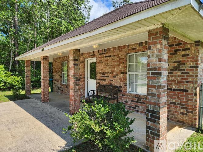 A brick house with a porch and a white door.