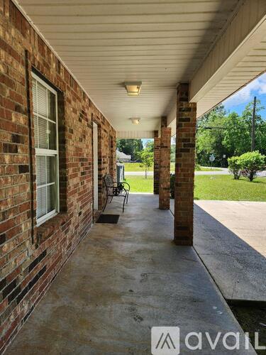 A porch with a bench and pillars.