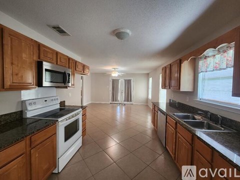 A kitchen with wooden cabinets and a white stove top oven.