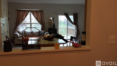 A kitchen counter with a bowl of fruit and a bottle of wine on it.