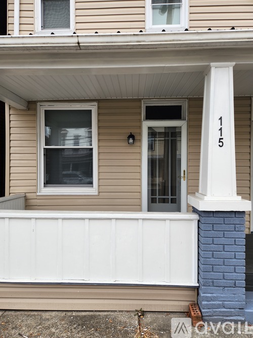 A house numbered 115 has a white porch.