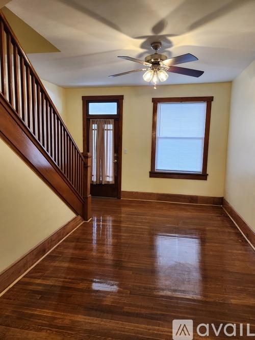 A room with wooden floors and a ceiling fan.