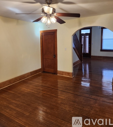 A room with a wooden floor and a ceiling fan.