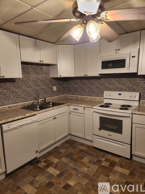 A kitchen with white cabinets and a checkered floor.
