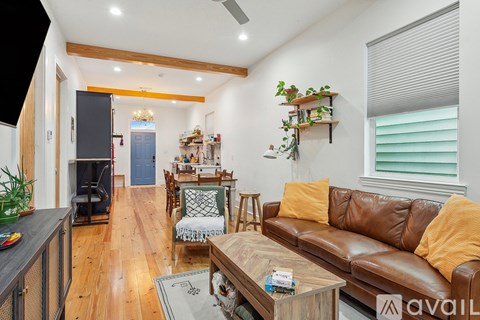 A living room with a brown leather couch and a coffee table.