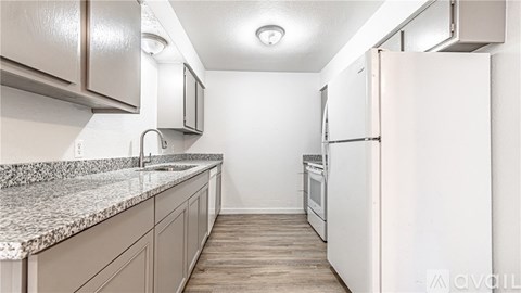 A kitchen with white cabinets and a granite countertop.