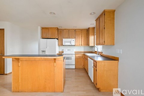 A kitchen with wooden cabinets and appliances.
