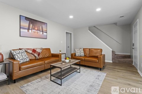 A living room with a brown leather couch and a coffee table.