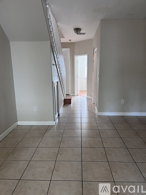 A long hallway with tiled floors and white walls.