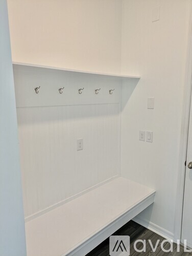 A white bench is in the corner of a room.