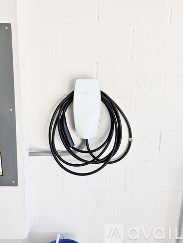 A white electrical outlet with a white cord plugged in.