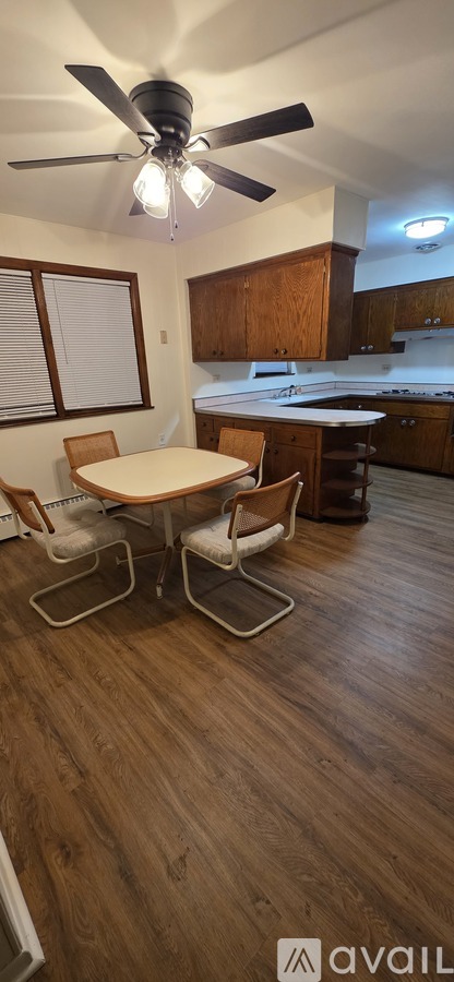 A room with a table and chairs and a ceiling fan.