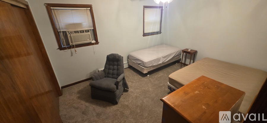 A bedroom with a bed, chair, and table.
