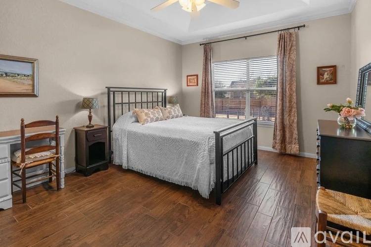 A bedroom with a large bed, a chair, and a dresser.