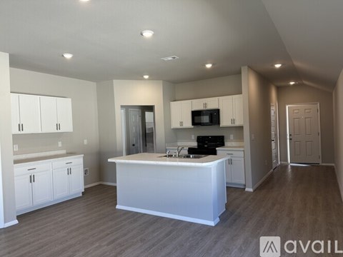 A kitchen with white cabinets and a large island.