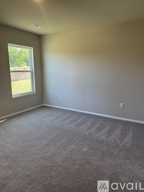 A room with a carpeted floor and a window.