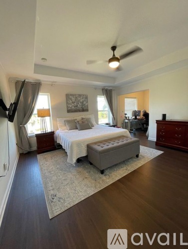 A bedroom with a bed, dresser, and ceiling fan.