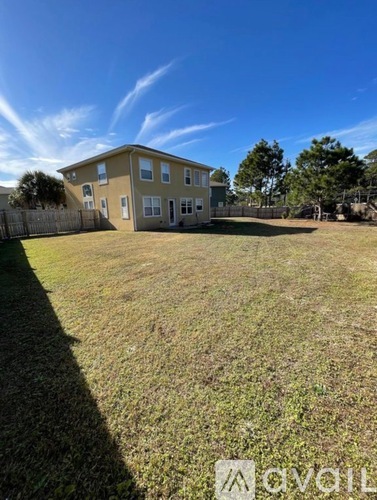 A house with a fence and a grassy yard.