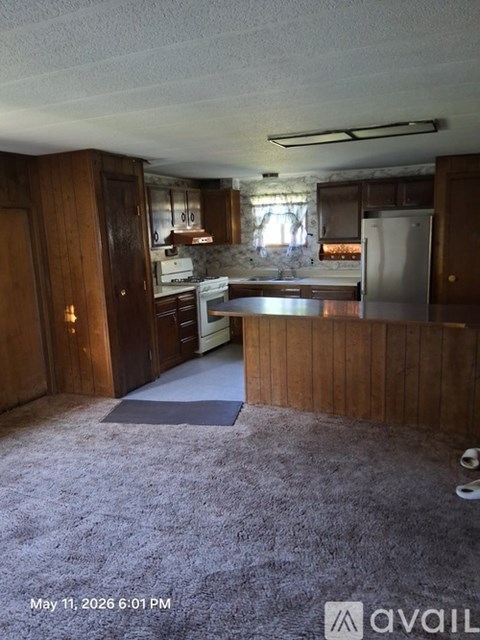 A kitchen with wooden cabinets and a white refrigerator.
