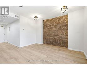 A room with a white wall and a brick wall.