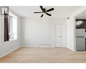 A white room with a ceiling fan and a yellow bench.
