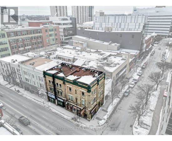 A snowy city street with a building that has a sign that says "Royal LePage Triland Realty Brokerage".