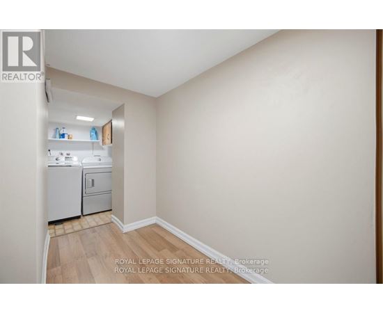 A small, empty room with a dishwasher and a refrigerator.