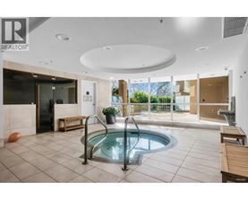 A large indoor swimming pool with a hot tub in the middle of the room.