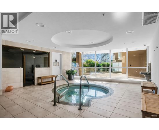 A large indoor swimming pool with a hot tub in the middle of the room.