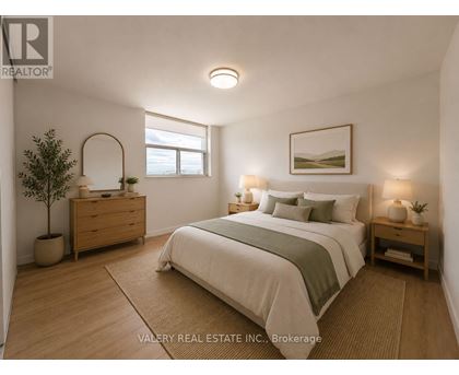 A bedroom with a bed, nightstand, and a plant.