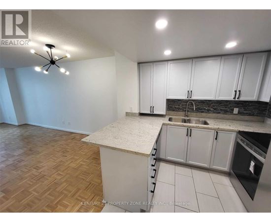 A kitchen with white cabinets and a wooden floor.