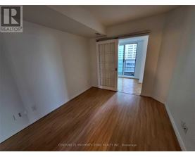 A room with wooden floors and a sliding door leading to a balcony.