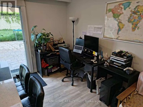 A room with a desk, chair, and a world map on the wall.