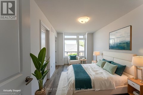 A bedroom with a bed, nightstand, and a plant.