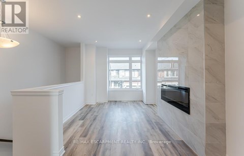 A spacious room with a fireplace and a large window.