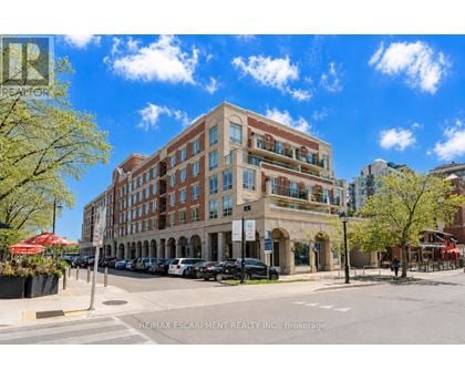 A street view of a multi-story building with a parking lot in front.