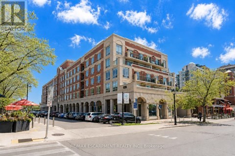 A street view of a multi-story building with a parking lot in front.